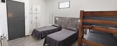 a room with two beds and a dresser in it at new bv carlos paz in Villa Carlos Paz