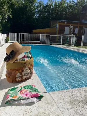 a hat and towels next to a swimming pool at Complejo cerca del rio in Villa Carlos Paz