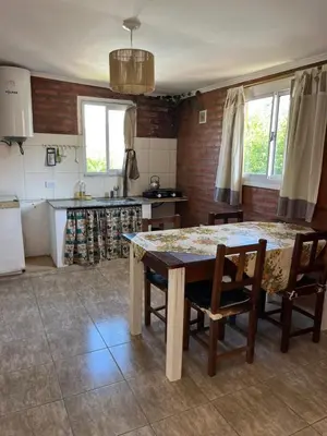 a kitchen with a table and chairs in a room at Complejo cerca del rio in Villa Carlos Paz