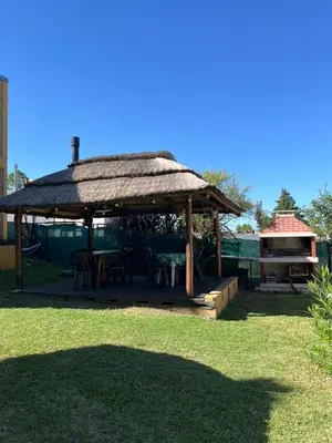 a gazebo with a table and a grill at Complejo cerca del rio in Villa Carlos Paz
