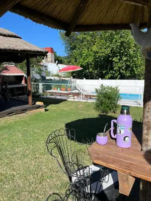 a picnic table with a jug and two mugs on it at Complejo cerca del rio in Villa Carlos Paz