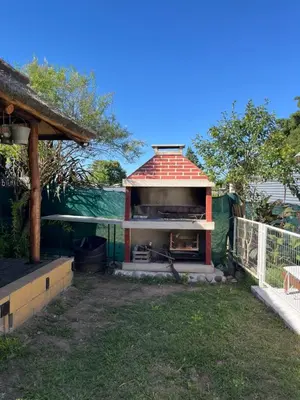 a small building with a roof on top of a yard at Complejo cerca del rio in Villa Carlos Paz