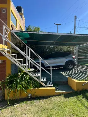 a car parked in a parking lot next to a building at Complejo cerca del rio in Villa Carlos Paz