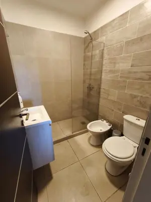 a bathroom with a shower and a toilet and a sink at Casa de campo Los Gurises in Alta Gracia