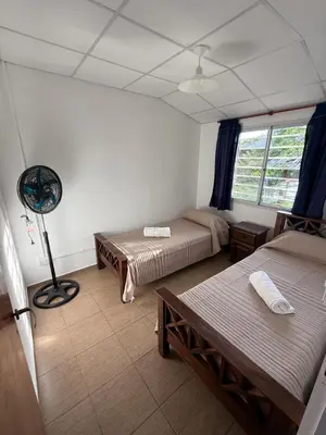 a room with two beds and a fan at Cabañas Marquetti in Potrero de Garay