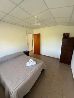 a bedroom with a bed with a towel on it at Cabañas Marquetti in Potrero de Garay