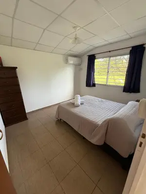 a bedroom with a bed and a window at Cabañas Marquetti in Potrero de Garay