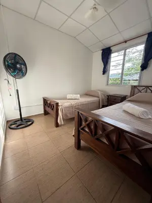 a room with two beds and a fan in it at Cabañas Marquetti in Potrero de Garay