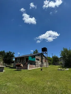 a building in a field with a grass field at El Parador de Tanti in Tanti