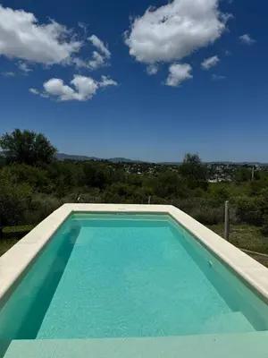 a swimming pool with a blue sky in the background at El Parador de Tanti in Tanti