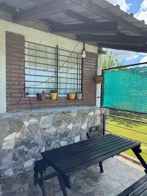 a wooden bench sitting in front of a window at El Parador de Tanti in Tanti