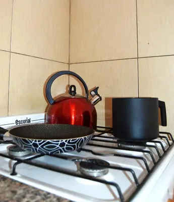 a red tea kettle sitting on top of a stove at Bellísimo apartamento con vistas a la ciudad in La Porteña
