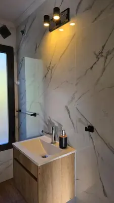 a bathroom with a sink and a marble wall at La Soñada in San Roque