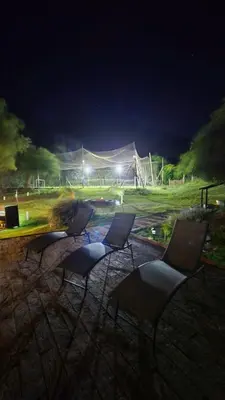 three chairs sitting in front of a field at night at La Soñada in San Roque