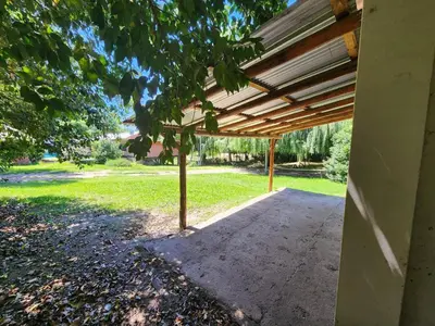 a wooden pergola on the side of a house at Rincón de Paz in Los Reartes