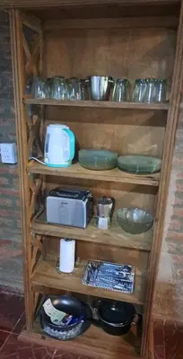 a wooden shelf with plates and bowls on it at Rincón de Paz in Los Reartes