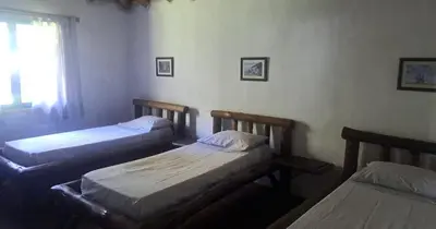 two twin beds in a room with a window at Rincón de Paz in Los Reartes