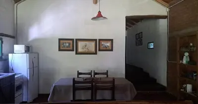 a kitchen with a table and chairs and a refrigerator at Rincón de Paz in Los Reartes