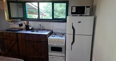 a kitchen with a white refrigerator and a stove at Rincón de Paz in Los Reartes