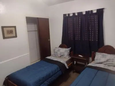 a small room with two beds and a window at Refugio Serrano Carlos Paz parque y pileta privada in Villa Carlos Paz