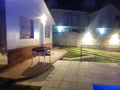 a table sitting outside of a building at night at Refugio Serrano Carlos Paz parque y pileta privada in Villa Carlos Paz