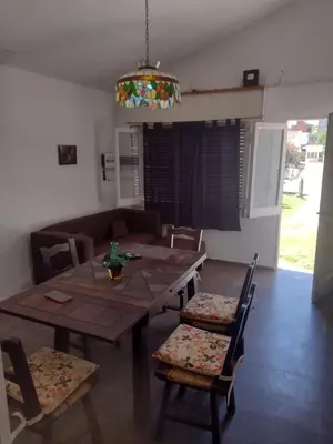 a dining room with a wooden table and chairs at Refugio Serrano Carlos Paz parque y pileta privada in Villa Carlos Paz