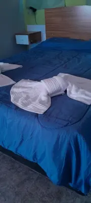 a white blanket laying on top of a blue bed at Monoambiente Pilu in Villa Cura Brochero