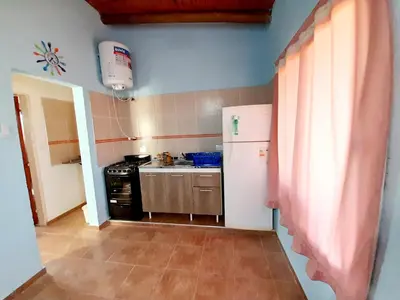 a small kitchen with a refrigerator and a stove at Brisas de las Sierras 2 in Tanti
