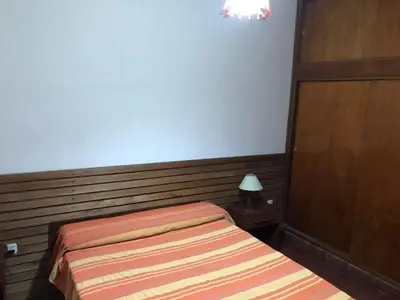 a bedroom with a bed and a wooden headboard at El Sauce casa de verano in Mina Clavero