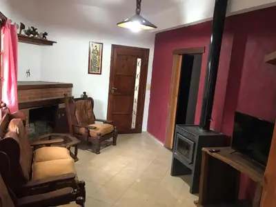 a living room with a fireplace and a tv at El Sauce casa de verano in Mina Clavero