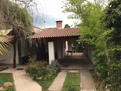 a small house with a red tile roof at El Sauce casa de verano in Mina Clavero
