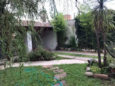 a garden with a hose in the grass at El Sauce casa de verano in Mina Clavero