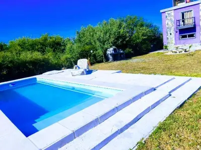a swimming pool with a chair next to a house at Casa grande Flor Silvestre in Carpintería
