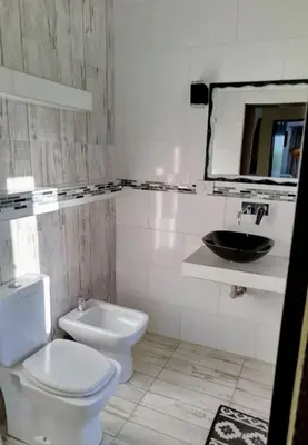 a bathroom with a white toilet and a sink at Casa grande Flor Silvestre in Carpintería