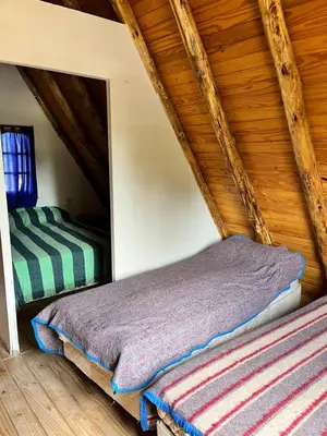 a room with two beds in a attic at Cabañas La Juana in San Luis