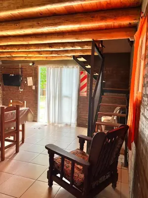 a rocking chair in a room with a staircase at Cabañas La Juana in San Luis