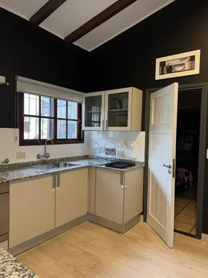 a kitchen with white cabinets and a sink at Villa Socrates in Villa Carlos Paz