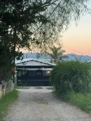 a house with a driveway next to a building at Villa Socrates in Villa Carlos Paz