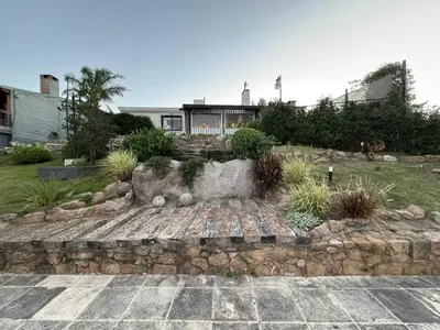 a garden with a stone path and a house at Villa Socrates in Villa Carlos Paz