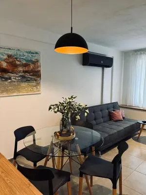 a living room with a couch and a glass table at Departamento luminoso y acogedor en Alberdi in Cordoba