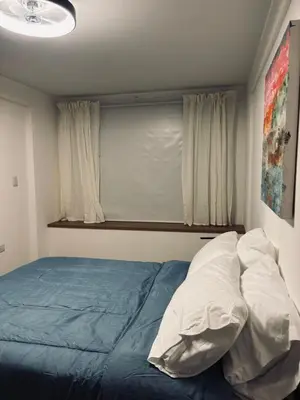 a bedroom with a blue bed with white pillows at Departamento luminoso y acogedor en Alberdi in Cordoba