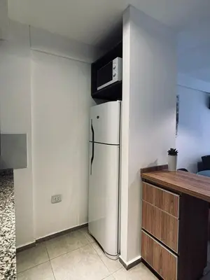 a kitchen with a refrigerator and a microwave at Departamento luminoso y acogedor en Alberdi in Cordoba