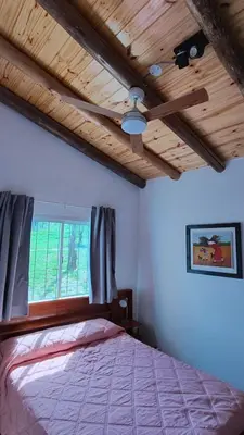 a bedroom with a bed with a wooden ceiling at Cabaña Cecilia II in Villa Icho Cruz