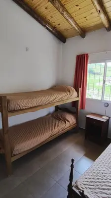 a bedroom with two bunk beds and a window at Cabaña Cecilia II in Villa Icho Cruz