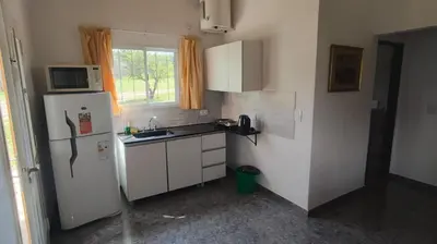 a small kitchen with a refrigerator and a microwave at Cabaña Cecilia II in Villa Icho Cruz