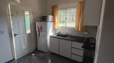 a kitchen with a white refrigerator and a microwave at Cabaña Cecilia II in Villa Icho Cruz