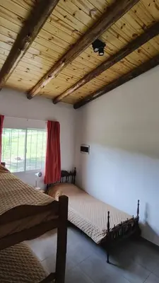 a bedroom with two beds and a wooden ceiling at Cabaña Cecilia II in Villa Icho Cruz