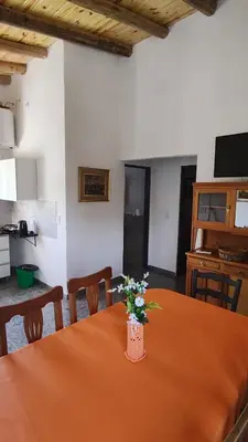 a room with a table with a vase of flowers on it at Cabaña Cecilia II in Villa Icho Cruz