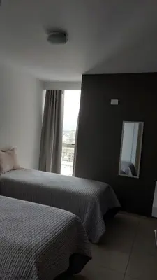 a hotel room with two beds and a mirror at Departamento en Cordoba, Torre Nubis in Cordoba