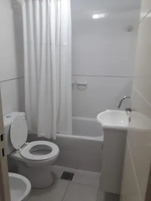 a white bathroom with a toilet and a sink at Departamento en Cordoba, Torre Nubis in Cordoba